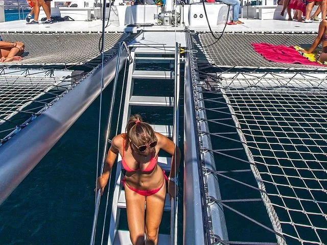 Woman in red bikini climbing steps on a catamaran at Taboga Island