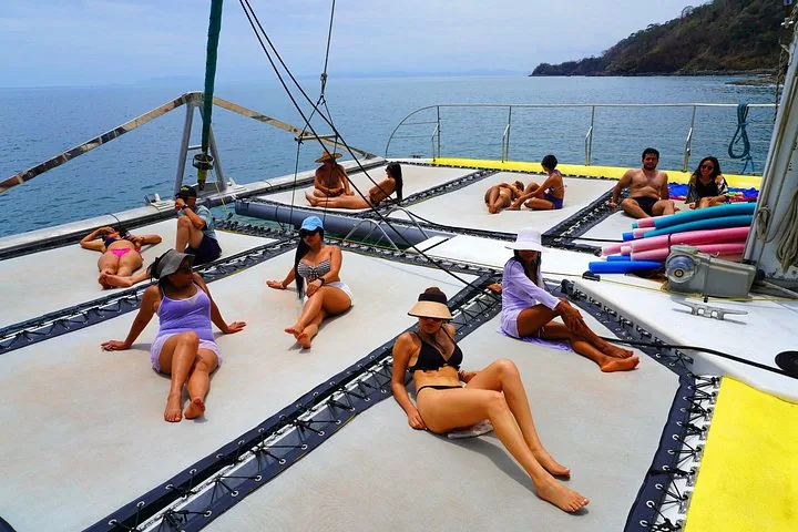 Women relaxing in swimwear on the lounging nets of a catamaran